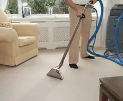 Carpet cleaning professional removing dirt and stains with a hot-water extraction tool in a home, Jacksonville, FL.