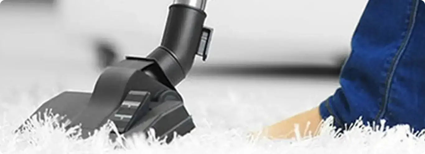 Close-up of a professional vacuuming a white carpet in Callahan.